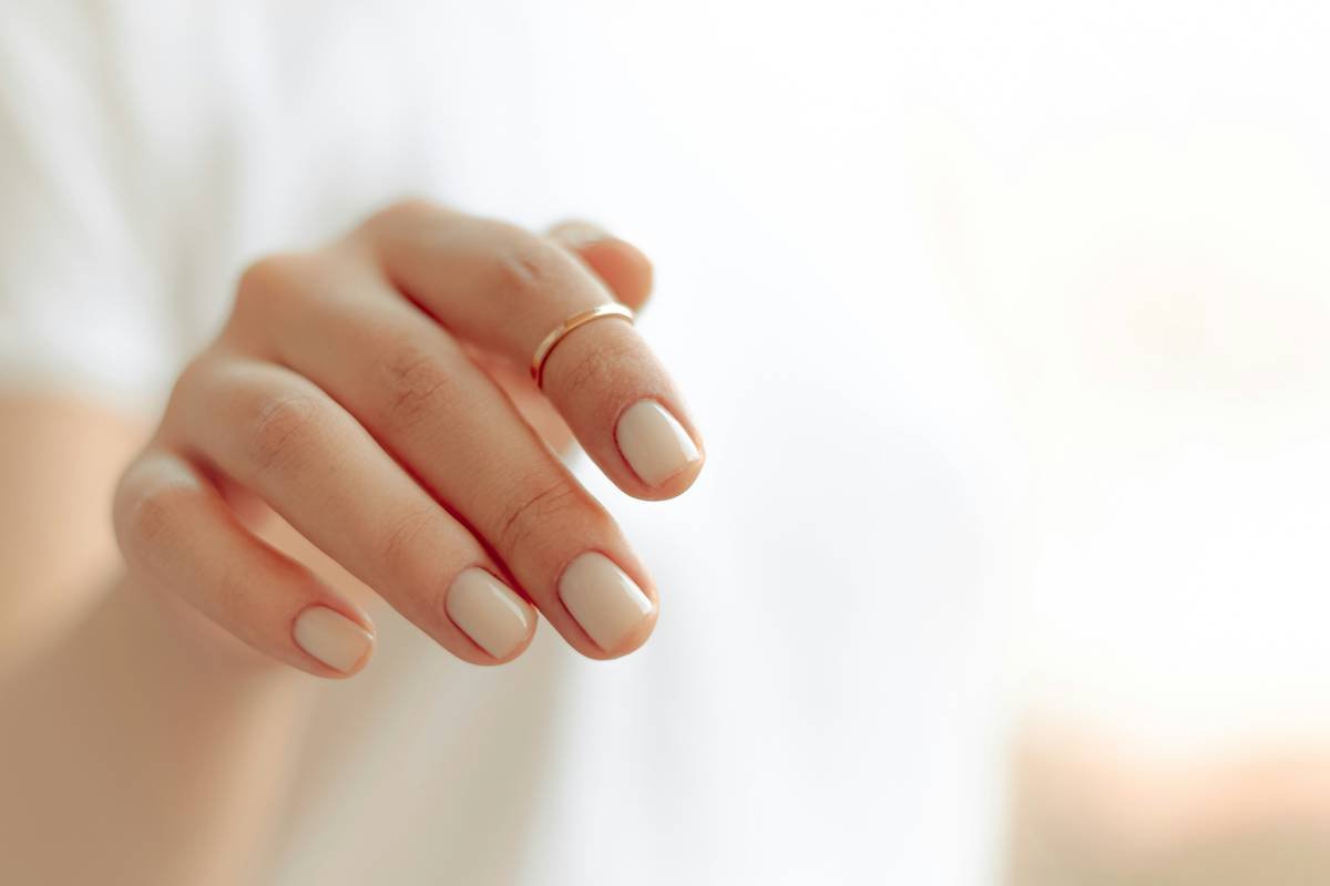 Infographic showing causes of brittle nails vs. healthy nail structure