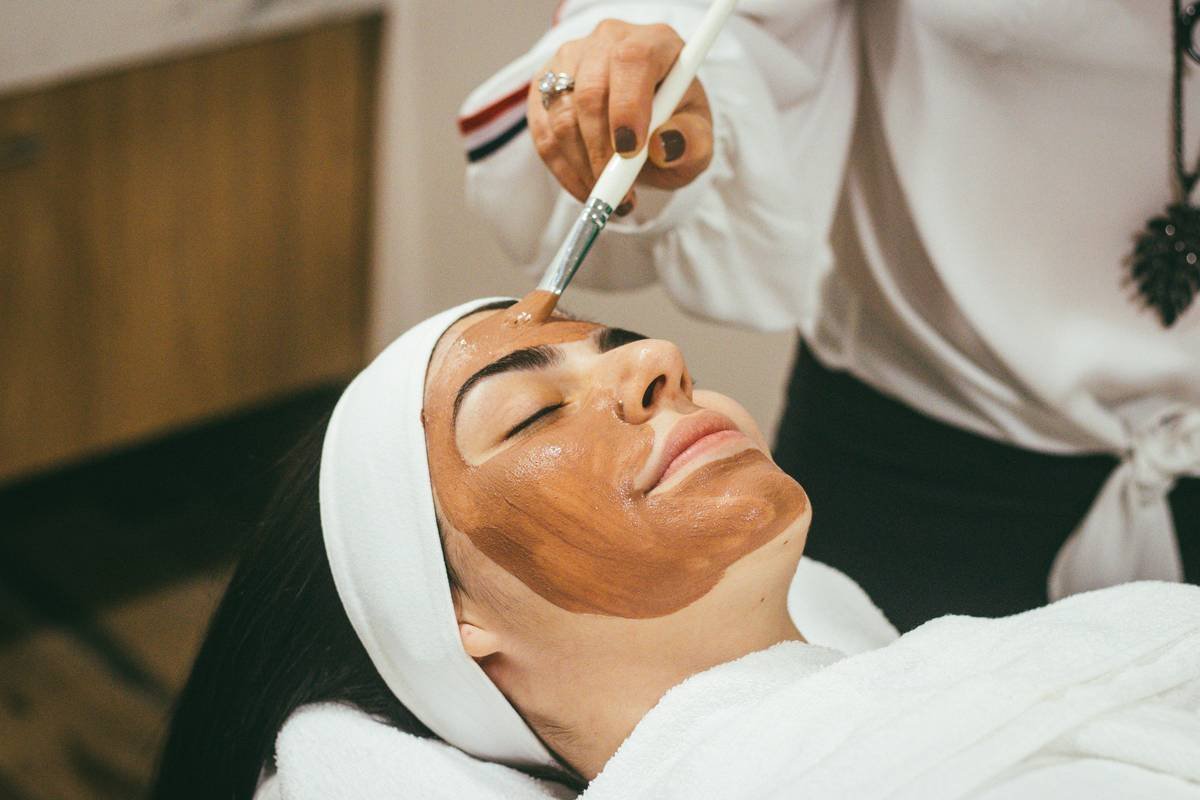 Woman applying nail grooming cream to cuticles and nail beds for healthy maintenance